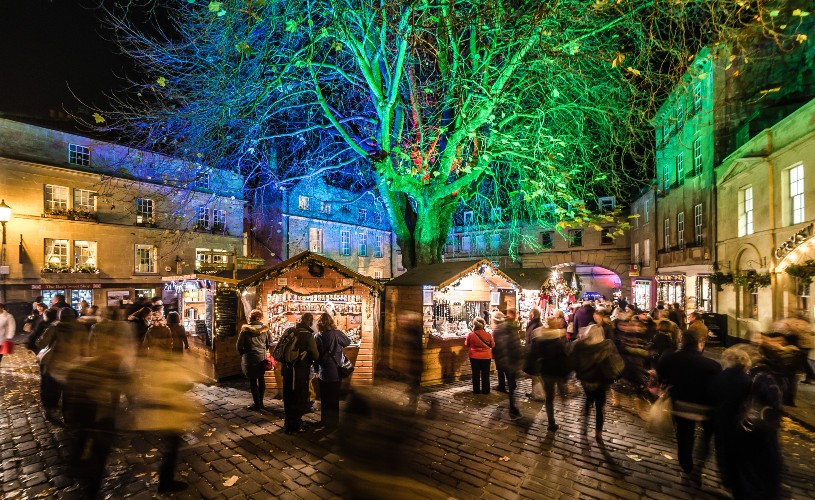 Bath Christmas Market stalls and tree lit up in green and blue